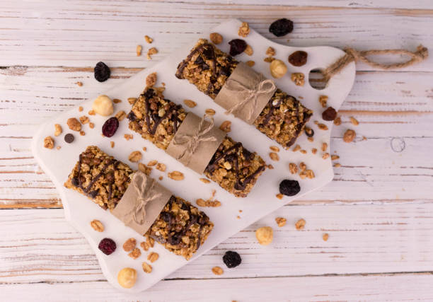 Three granola cereal bars on a white wooden background. Flat lay. stock photo
