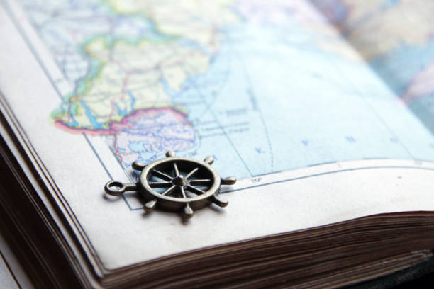 istock Summer travel idea. Smoll nautical steering wheel and map. 1398106283