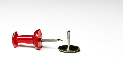 Overhead shot of screw and nail head on white background.