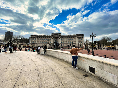 London, United Kingdom - March 6 2022: tourists at the queen victoria memorial and on the mall side of the royal palace Buckingham Palace