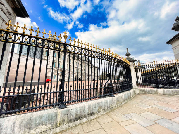 french lily on fence of Buckingham Palace London London, United Kingdom - March 6 2022: rounded black fence of Buckingham Palace with gold color french lily song title stock pictures, royalty-free photos & images