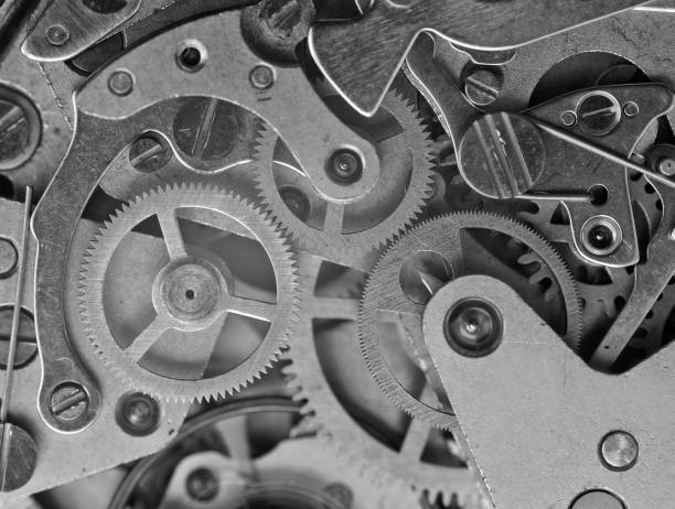 istock Manufacturing or industrial background. Concept Teamwork or idea Technology. Gears and cogs in clockwork. Macro. Black and white 1398111347