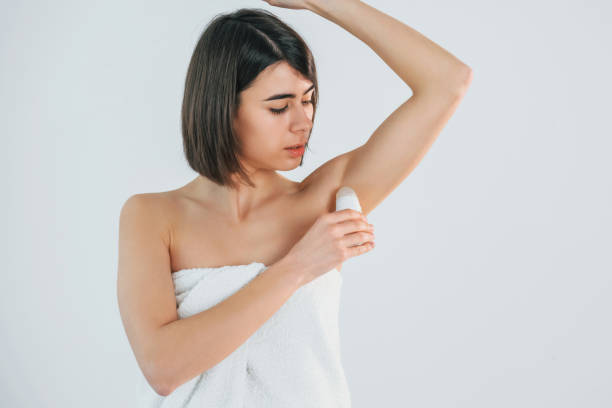 istock Using ball deodorant. Young brunette is indoors against white background 1398111505