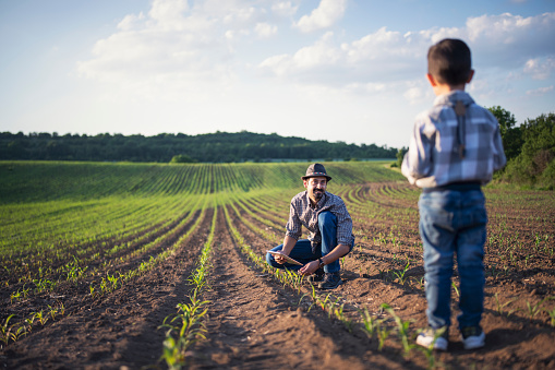 Farmer showing his son the family business in agriculture.