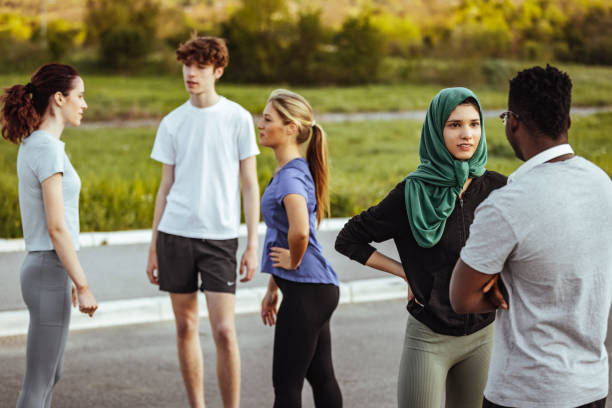 istock Young friends talking in a public park before running 1398112673