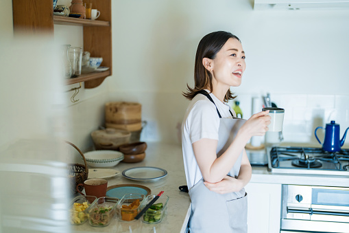 A woman relaxing in the kitchen while cooking