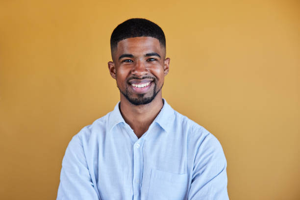 istock Smiling young businessman standing against a yellow background 1398114783