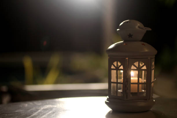 istock White lantern and the candle light inside on the table in the night. 1398116150
