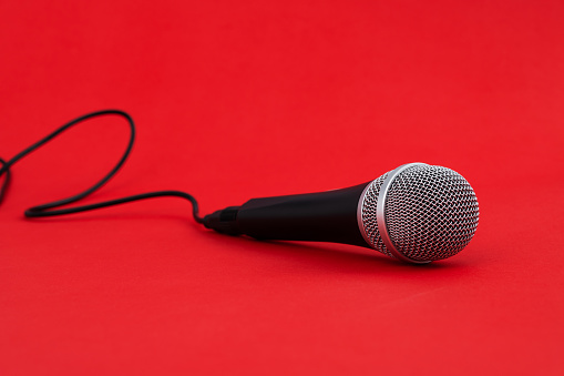 Microphone with cable on red background.