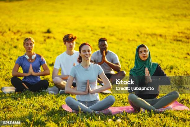 Diverse multiracial people meditating in lotus pose