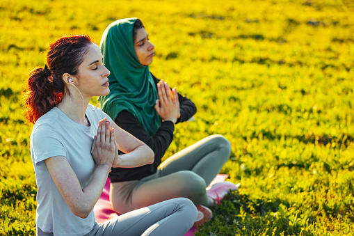 Two yoga girls praying in lotus position stock photo