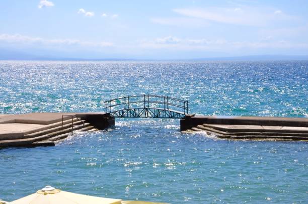 small walking bridge on slatina beach in opatija city.croatia, beautiful opatija riviera on kvarner, popular beach slatina and pedestrian bridge in scenic tourist resorts - europe bridge editorial eastern europe imagens e fotografias de stock