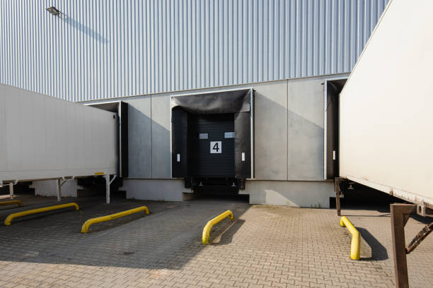istock trucks and trailers at loading ramps of a warehouse 1398119653
