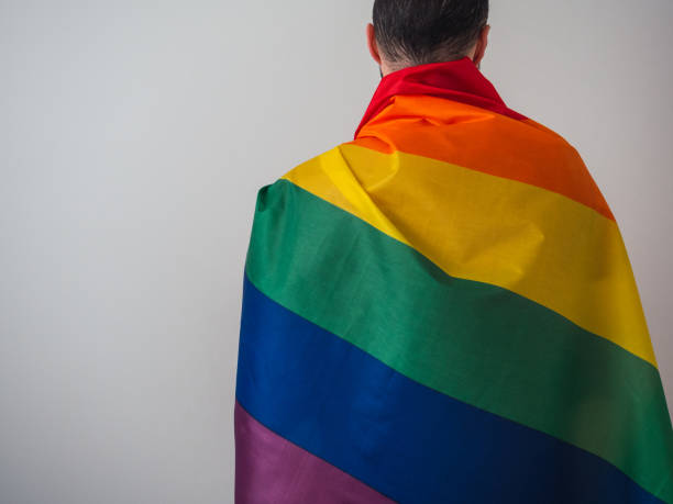 istock Unrecognizable man with his back to camera with LGBT flag and copy space 1398120526