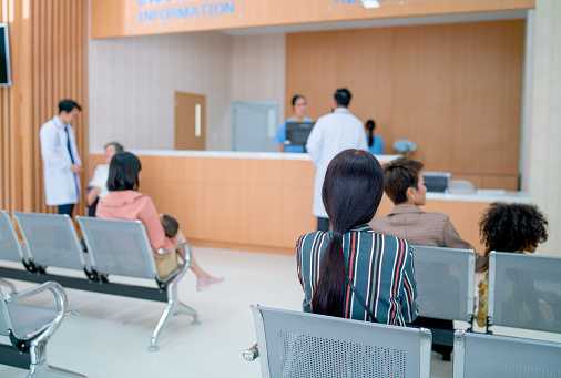 Group of doctors, nurse and patients stay in area of information or reception counter in hospital.