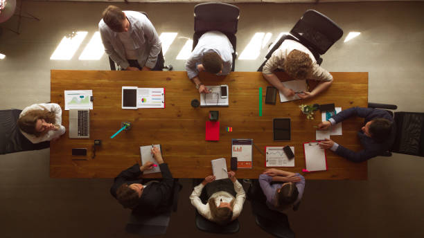 istock Aerial view of young people, co-workers during work process, meeting at office, indoors. Work, finance, tech and business concept. 1398121814