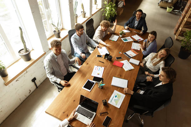 istock Aerial view of young people, co-workers during work process, meeting at office, indoors. Work, finance, tech and business concept. 1398121823