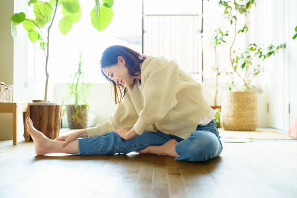 frau, die sich im raum streckt - floor women sitting yoga stock-fotos und bilder