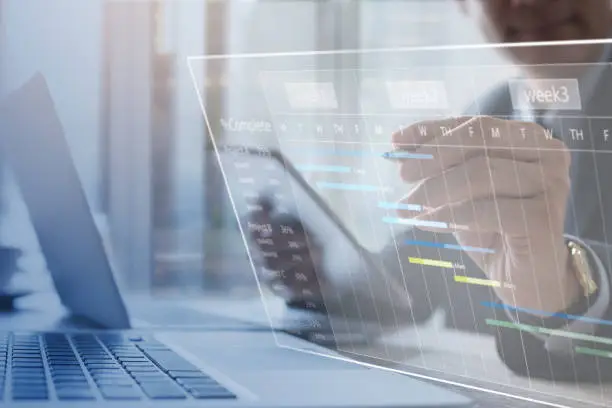 Project management. Project manager updating tasks and milestones progress planning with augmented reality Gantt chart scheduling on virtual screen