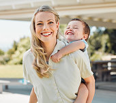 istock Happy single mother giving her little son a piggyback ride outside in a garden. Smiling caucasian single parent bonding with her adorable child in the backyard. Playful kid enjoying free time with mom 1398122057