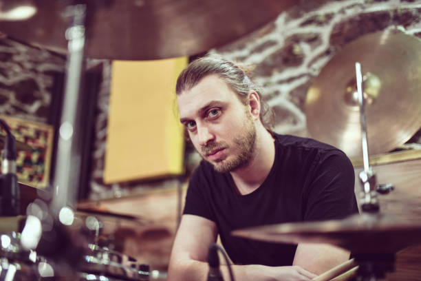 istock Handsome Bearded Male Drummer Focused At His Work Post 1398124938