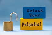 Unlock your potential text on wooden blocks with pad lock on light blue background.