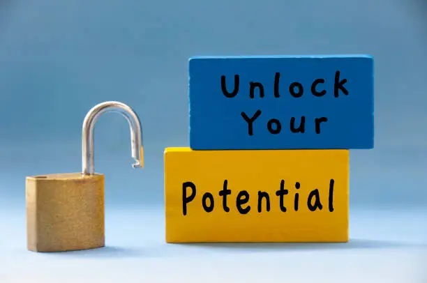 Photo of Unlock your potential text on wooden blocks with pad lock on light blue background.