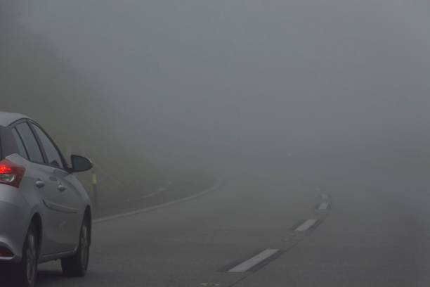 istock Foggy highway. Car going down the mountain. Low visibility. 1398128813