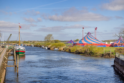 View to a circus tent across the river named Ribe Å in Ribe, which is the oldest town in Denmark and is situated to the south west on the peninsular Jutland