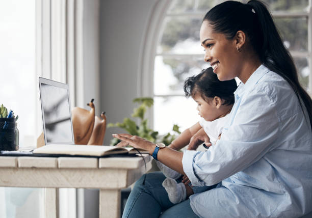 scatto di una giovane madre che si prende cura della sua bambina mentre lavora da casa - work life balance foto e immagini stock