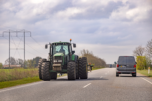 Heavy tractor on a small road in a  agricultural district on the Danish peninsular Jutland