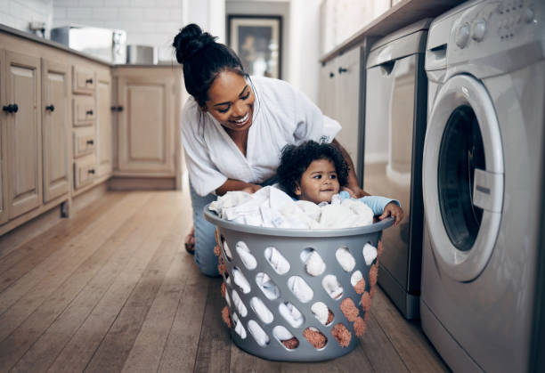 Shot of a young mother playfully bonding with her baby girl while doing the laundry at home There's no better love laundromat laundry residential structure cleaning stock pictures, royalty-free photos & images