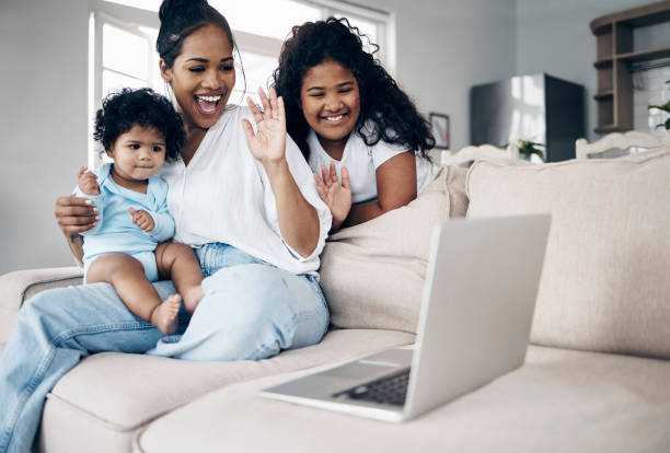 istock Shot of a young mother using a laptop with her daughters on the sofa 1398131705