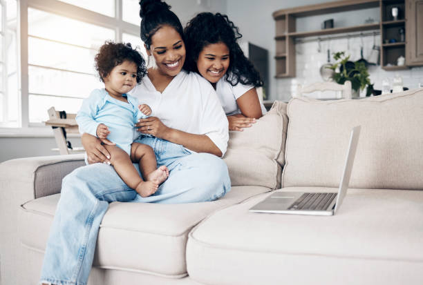 istock Shot of a young mother using a laptop with her daughters on the sofa 1398132195