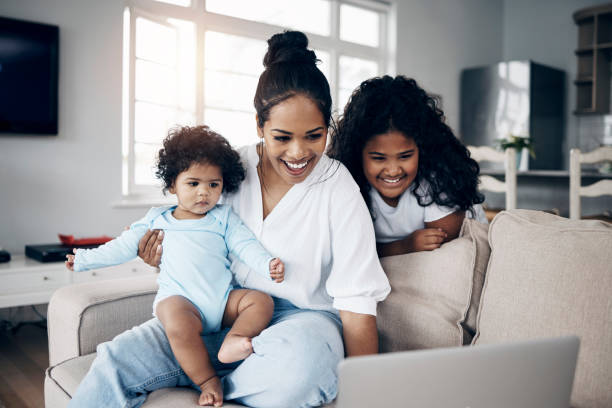 istock Shot of a young mother using a laptop with her daughters on the sofa 1398132214