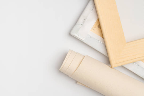 Wooden stretchers, and a roll of canvas on a white background in a frame workshop, copy space