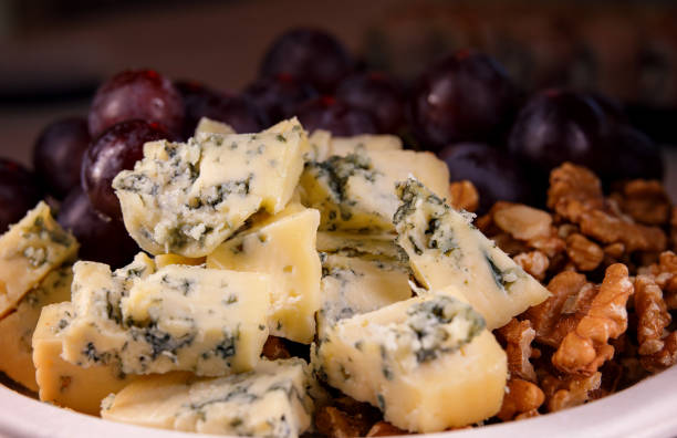 A plate of grape cheese and walnut. Cheese with mold.