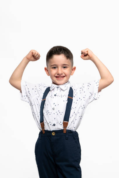 White background, proud, strong little boy showing arms muscles stock photo