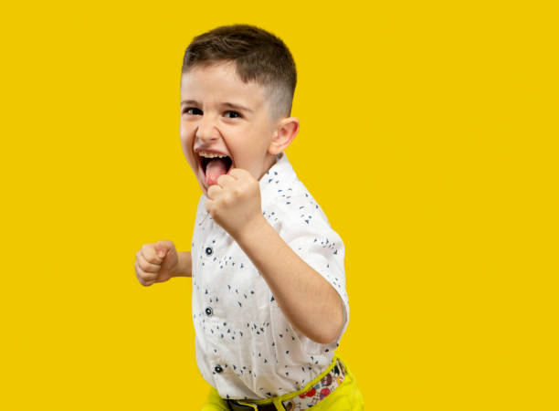 The joy movement of a successful and ambitious cute boy, Yellow background stock photo