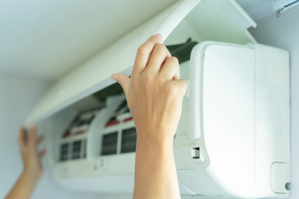 nahaufnahme des reparateurs hand öffnen der abdeckung auf der klimaanlage, um staub oder bakterien im gerät zu hause für das lifestyle-konzept zu überprüfen oder zu reinigen - air conditioner window heat hot day stock-fotos und bilder