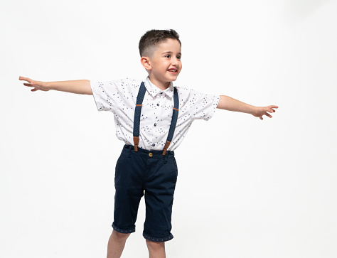 little cute boy dreams that he is flying with his arms up