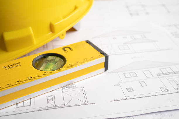 istock Architectural house plan project blueprint with yellow helmet and engineering construction tools. 1398137957