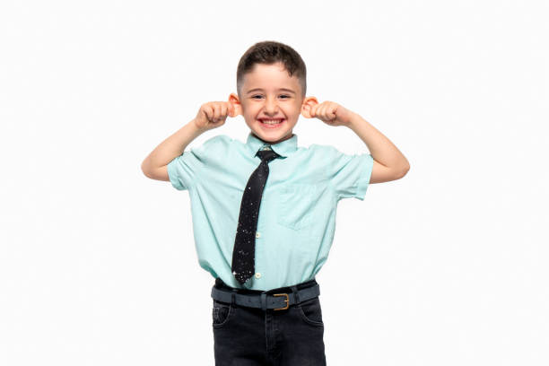 Cute little boy holding his ear laughs.Otoplasty stock photo