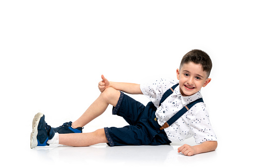 Cute happy stylish little couple child girl and boy in fashionable clothes sittting together at studio. kids fashion concept.