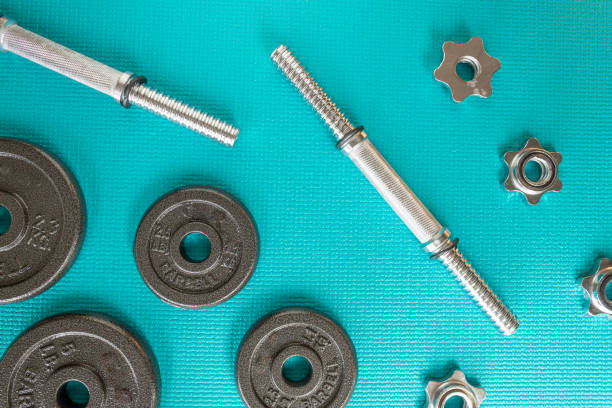 istock flat-lay barbells and bars on a blue turquoise excersice mat 1398141859