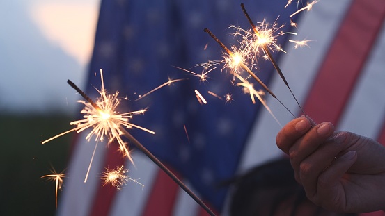 Feliz 4 de julio Día de la Independencia, Sosteniendo de la mano sparkler fuegos artificiales de celebración de EE.UU. con fondo de bandera estadounidense. Concepto de Cuatro de Julio, Día de la Independencia, Fuegos artificiales, Bengala, Memorial, Vet photo