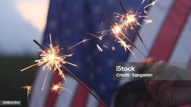 Happy 4th Of July Independence Day Hand Holding Sparkler Fireworks Usa Celebration With American Flag Background Concept Of Fourth Of July Independence Day Fireworks Sparkler Memorial Veterans Stock Photo - Download Image Now