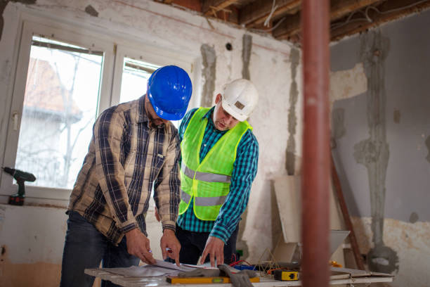 istock Team of workers at construction site discussing about the project 1398143422