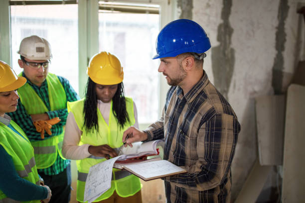 istock Building contractor showing blueprints to construction site workers 1398143957