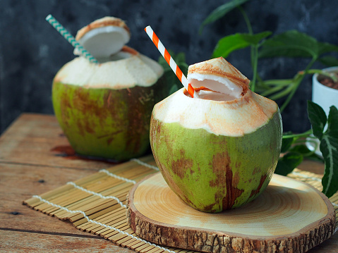 Young coconut  ready to eat on a wooden table for summer drinks concept.